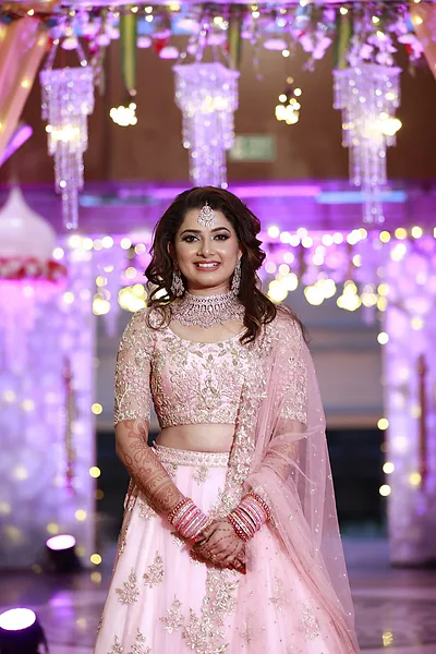 Bangalore bride in pink lehenga with bridal makeup and luminous highlight.