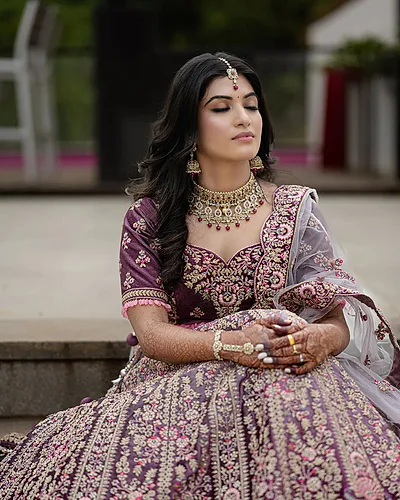 Bangalore bride in a plum lehenga with bridal makeup and luminous highlight.