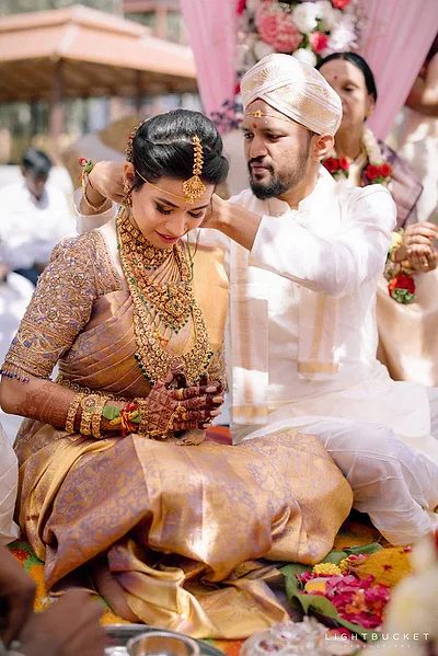 Bangalore bride in gold kanjivaram saree with bridal makeup and luminous highlight.